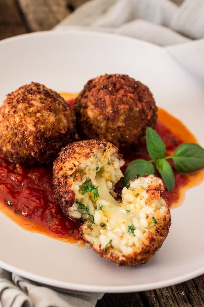 Arancini Di Riso with Balsamic Vinegar and Caramelized Onions Marinara Sauce | www.oliviascuisine.com | These risotto balls stuffed with cheese are an easy and delicious Italian antipasto! The recipe includes a basic parmesan risotto recipe, but you can absolutely use leftover risotto.