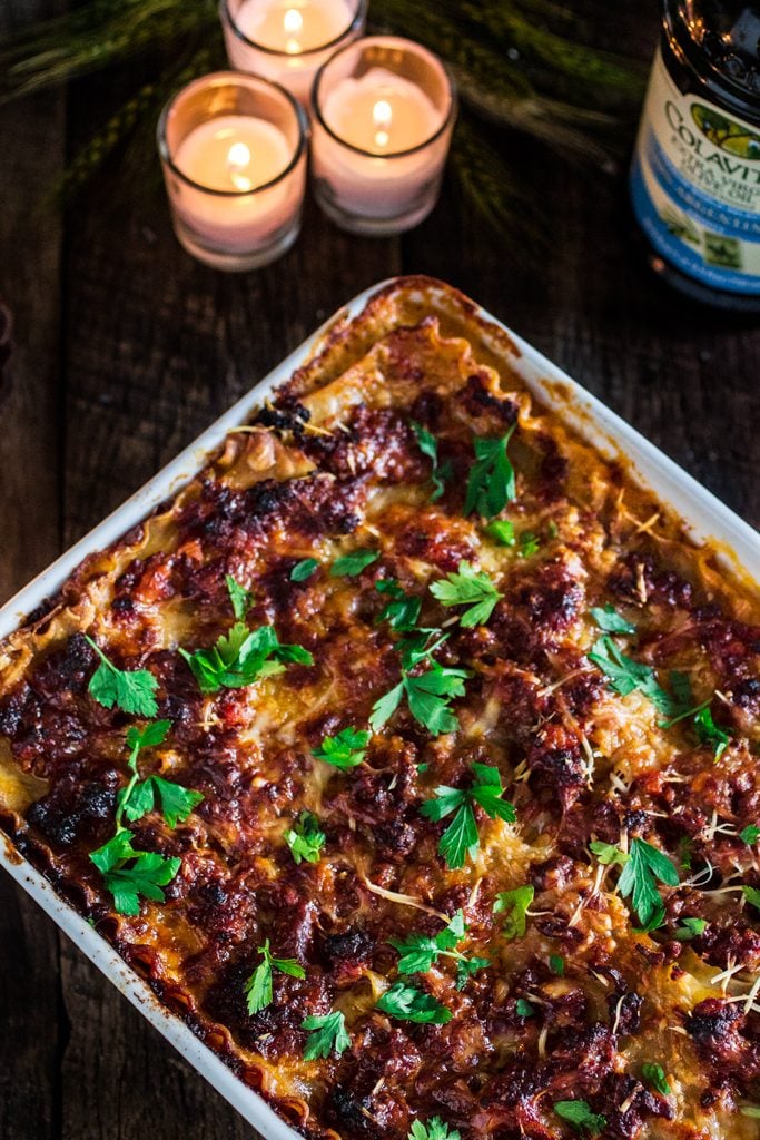 A lasagna dish with lasagna bolognese, garnished with parsley.