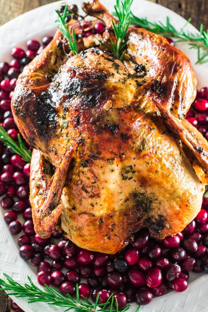 Roasted Turkey with Herb Butter | www.oliviascuisine.com | Looking for a good turkey recipe for Thanksgiving or Christmas? Look no further! This turkey is roasted with a parsley, lemon and garlic butter and covered in bacon (during roasting time) for amazing flavor and juiciness! 