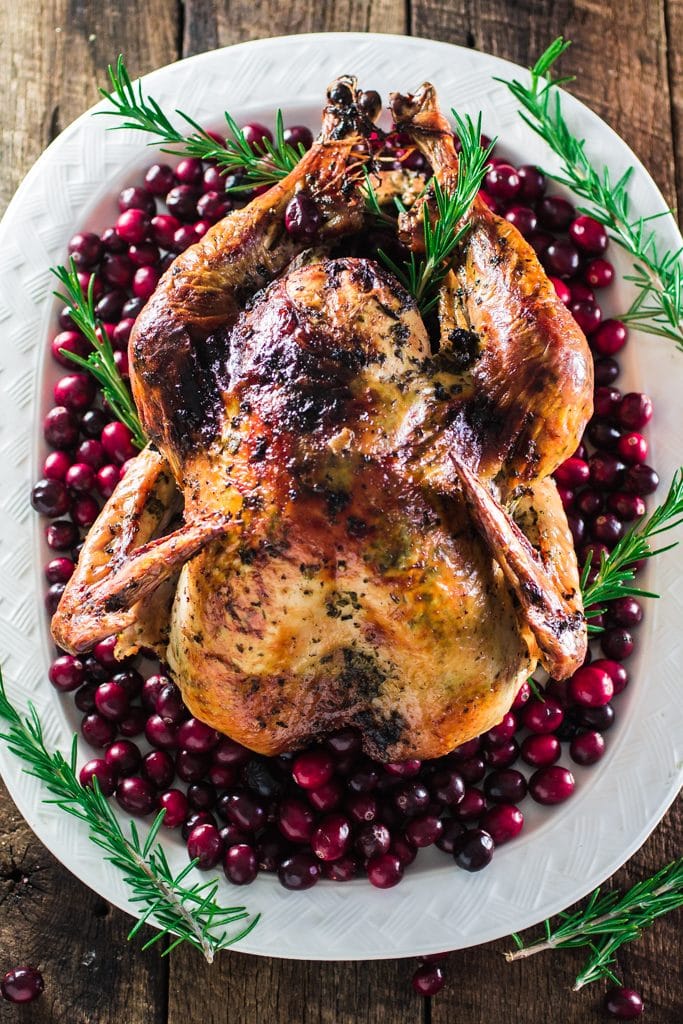 Roasted Turkey with Herb Butter | www.oliviascuisine.com | Looking for a good turkey recipe for Thanksgiving or Christmas? Look no further! This turkey is roasted with a parsley, lemon and garlic butter and covered in bacon (during roasting time) for amazing flavor and juiciness! 