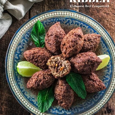 Kibbeh (Lebanese Beef Croquettes) | www.oliviascuisine.com | This Lebanese classic is one of my favorite dishes in the whole world! It consists of a dough made of meat, bulgur (cracked wheat), onions and mint leaves, formed into football shaped croquettes, and filled with more meat, onions, pine nuts and Middle Eastern spices. They are then deep fried to perfection so they are crisp on the outside and soft inside!