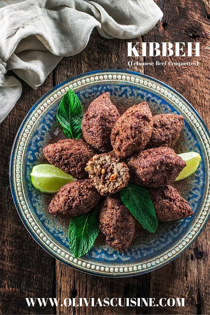 Kibbeh (Lebanese Beef Croquettes) | www.oliviascuisine.com | This Lebanese classic is one of my favorite dishes in the whole world! It consists of a dough made of meat, bulgur (cracked wheat), onions and mint leaves, formed into football shaped croquettes, and filled with more meat, onions, pine nuts and Middle Eastern spices. They are then deep fried to perfection so they are crisp on the outside and soft inside! 
