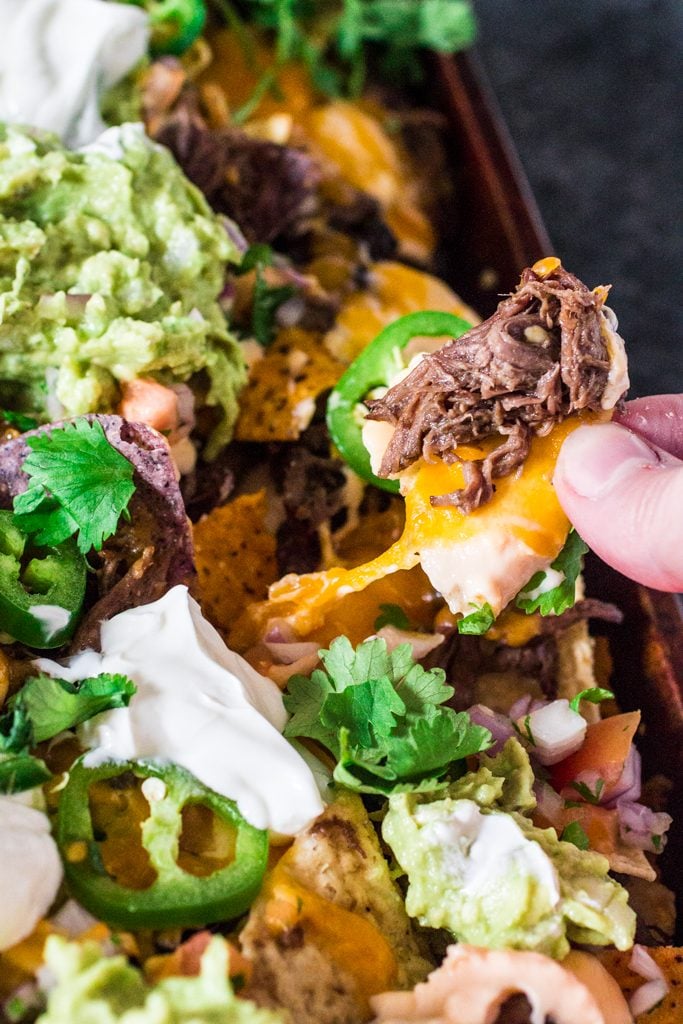 Fully Loaded Nachos | www.oliviascuisine.com | 9 layers of perfection: 3 different kinds of tortilla chips, Chipotle Beer Shredded Beef, Black Beans, the most incredible cheese sauce, more cheese, pico de gallo salsa, jalapeños, guacamole and sour cream or mexican crema! 