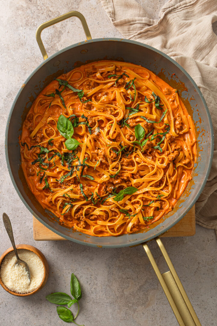 Overhead view of creamy one pot pasta with spicy sausage in a skillet