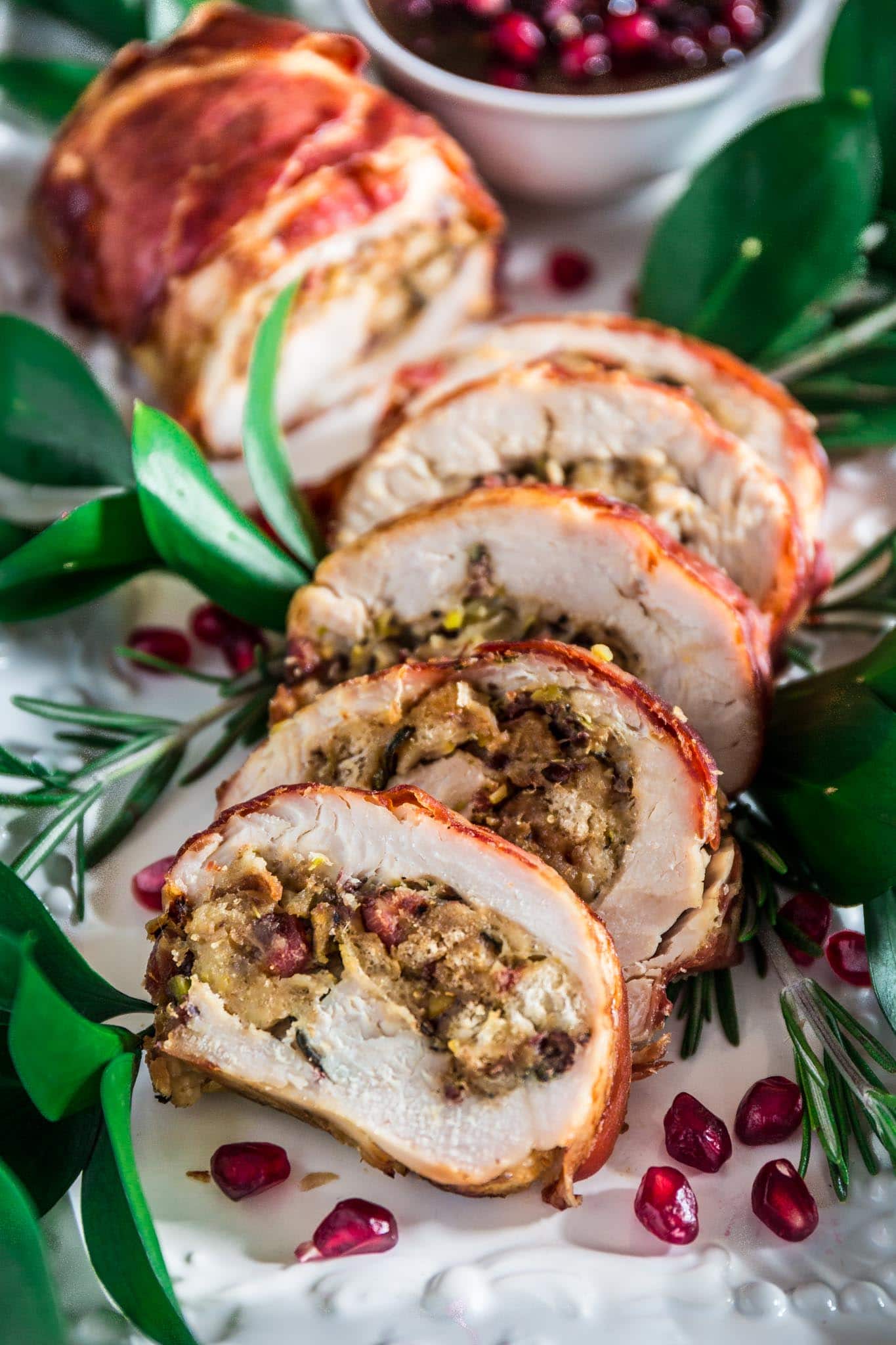 Prosciutto Wrapped Turkey Roulade with Pomegranate-Port Reduction Sauce | www.oliviascuisine.com | No time to roast a whole turkey? Knock the socks off your guests with this simple and quick to assemble turkey roulade. Moist, stuffed with pancetta, pistachio and cranberries, wrapped in Prosciutto di Parma and served with a lip-smacking pomegranate port reduction sauce. One bite and the holidays will never be the same again!