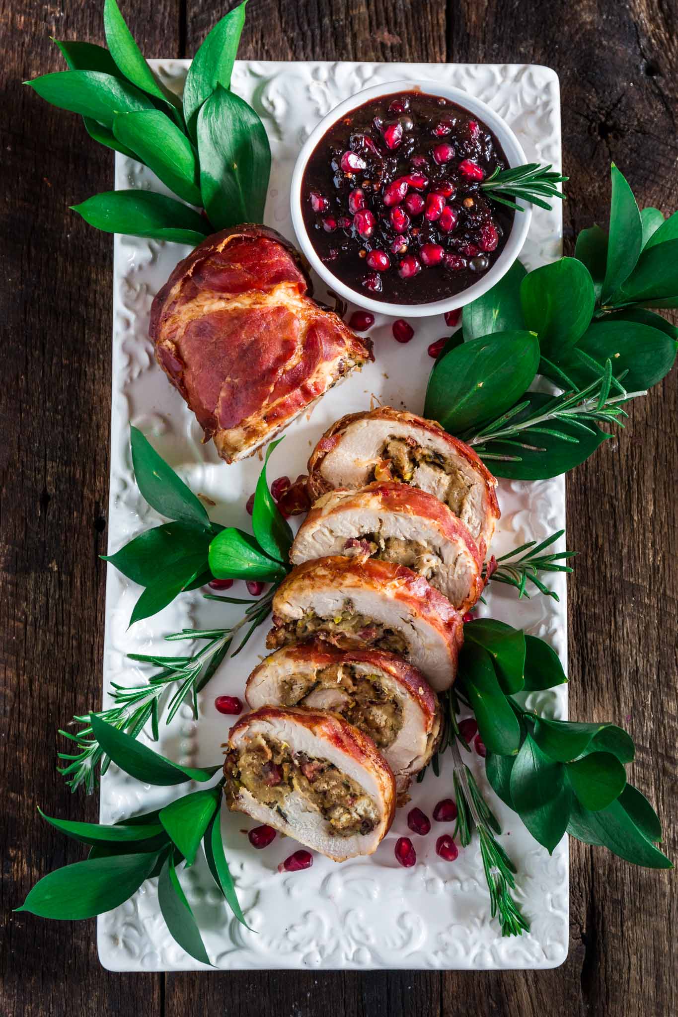 Prosciutto Wrapped Turkey Roulade with Pomegranate-Port Reduction Sauce | www.oliviascuisine.com | No time to roast a whole turkey? Knock the socks off your guests with this simple and quick to assemble turkey roulade. Moist, stuffed with pancetta, pistachio and cranberries, wrapped in Prosciutto di Parma and served with a lip-smacking pomegranate port reduction sauce. One bite and the holidays will never be the same again!