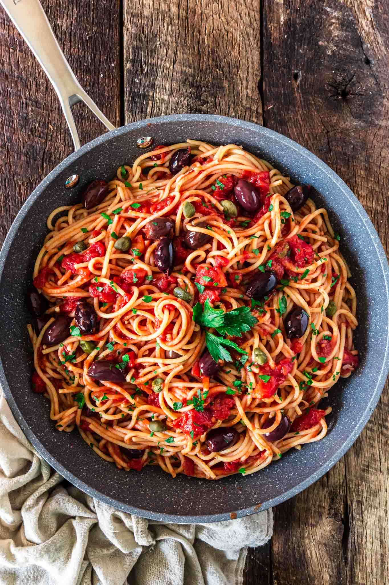 Spaghetti alla Puttanesca | www.oliviascuisine.com | Spaghetti alla Puttanesca is an Italian classic and a specialty of the Campania region. Consisting of tomatoes, garlic, olives, capers and anchovies (which are optional in my version), this dish is quick, deliciously aromatic and on the table in 20 minutes! (Recipe by @oliviascuisine.)