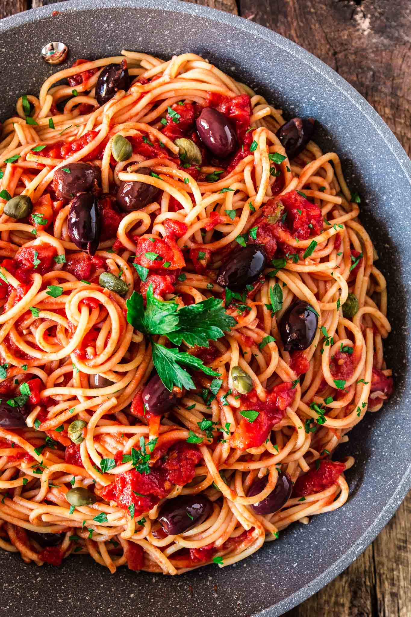 Spaghetti alla Puttanesca | www.oliviascuisine.com | Spaghetti alla Puttanesca is an Italian classic and a specialty of the Campania region. Consisting of tomatoes, garlic, olives, capers and anchovies (which are optional in my version), this dish is quick, deliciously aromatic and on the table in 20 minutes! (Recipe by @oliviascuisine.)