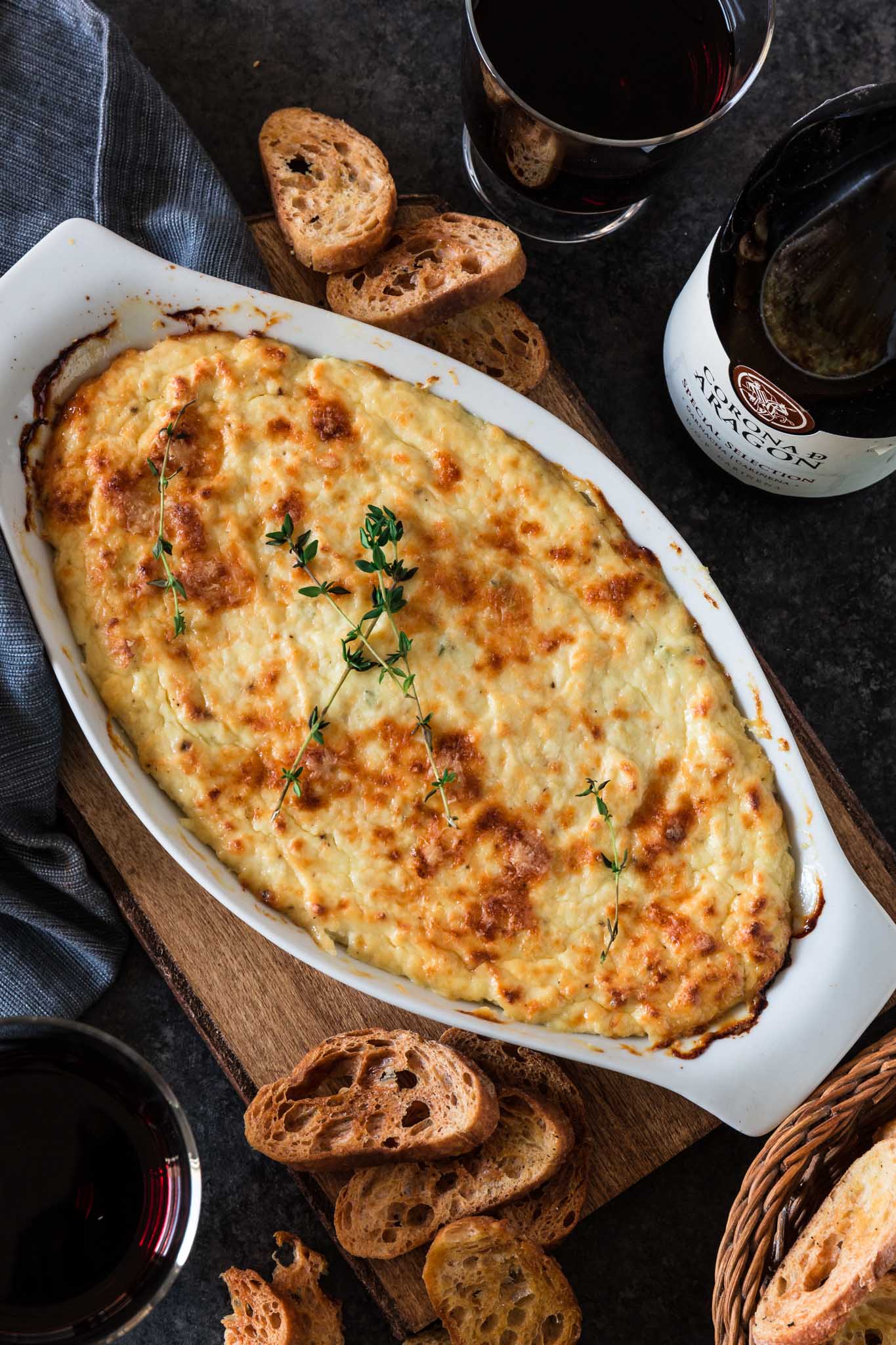 Roasted Garlic Baked Ricotta | www.oliviascuisine.com | Simple, yes. Mediocre? Never! This hot, cheesy and garlicky dip is all you'd want in an appetizer. Make it this holiday season, serve with some good wine and get ready to be called The Entertaining Queen/King. (Recipe and food photography by @oliviascuisine.)