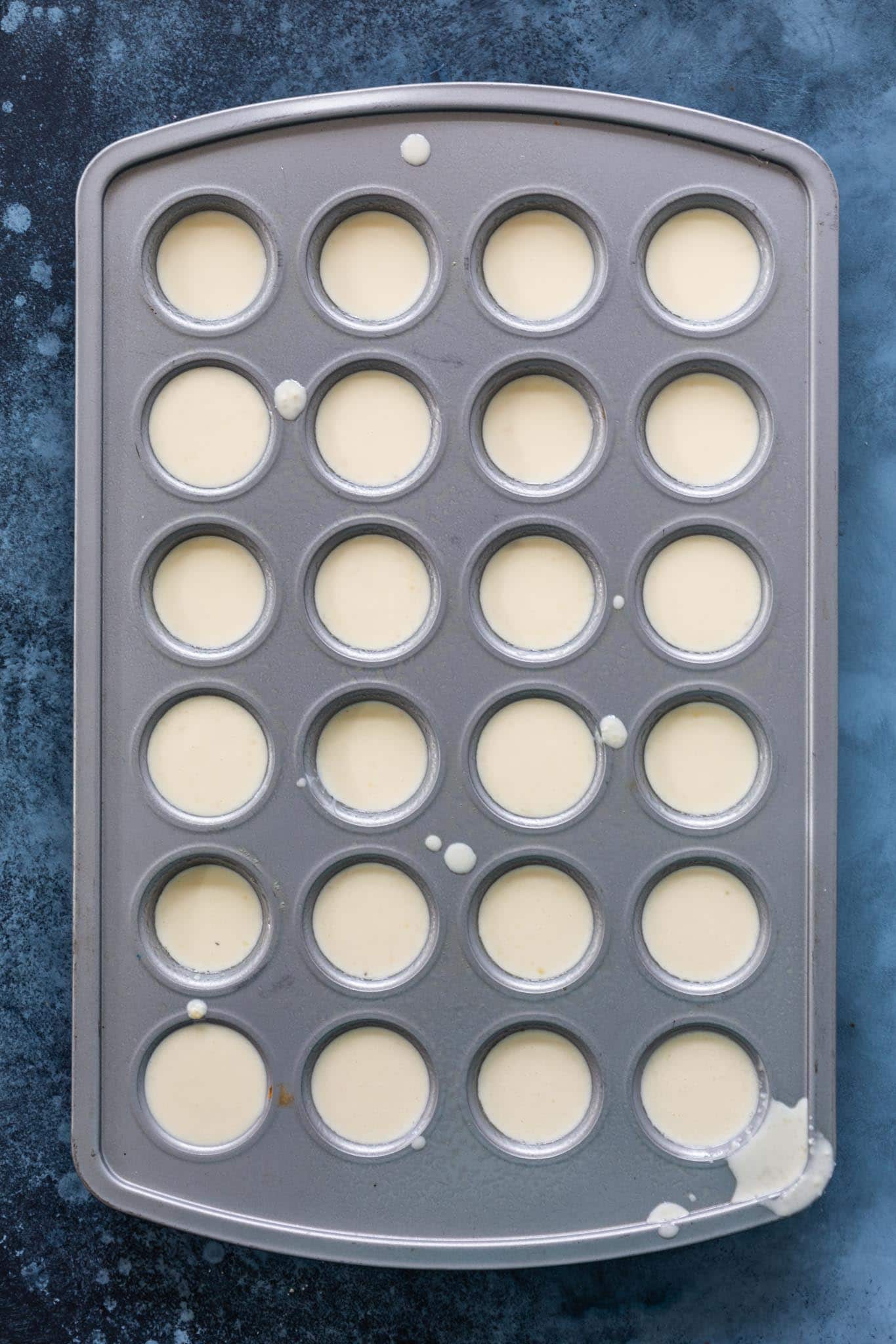 mini muffin tin filled with pao de queijo batter