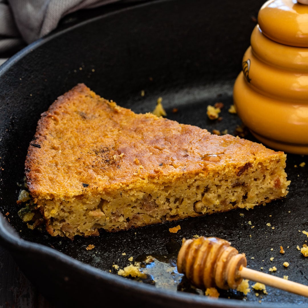 A slice of bacon cornbread with honey