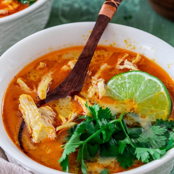 a bowl of Tom Kha Soup, garnished with cilantro and lime