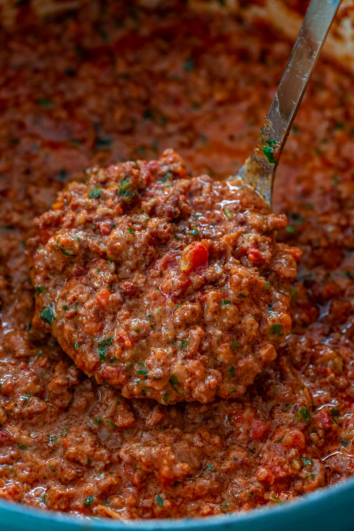 A ladle full of bolognese sauce.