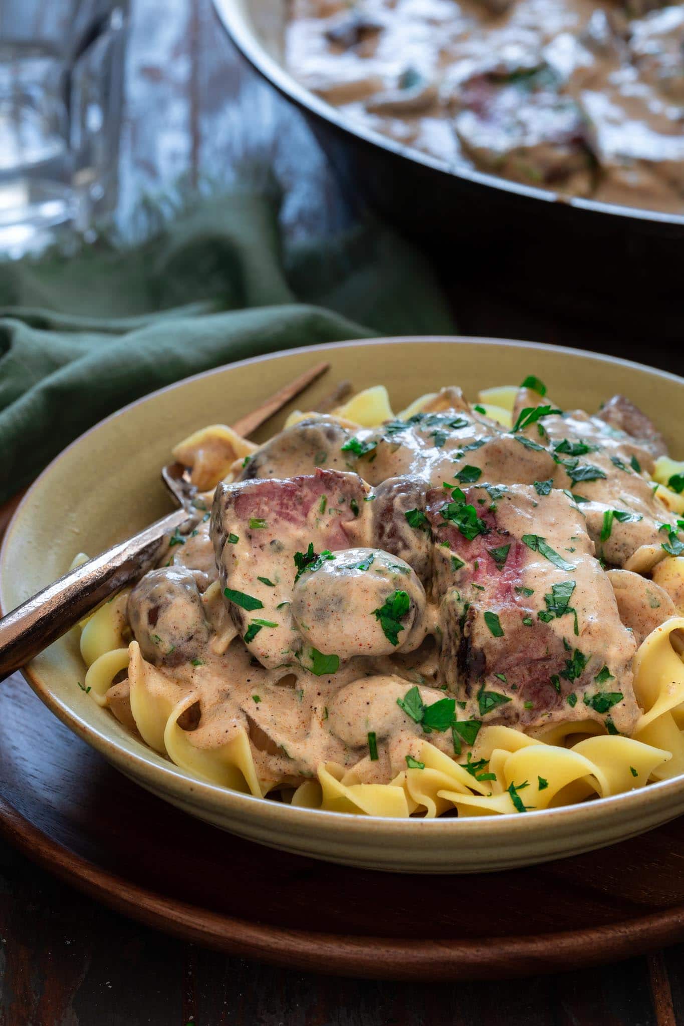 A serving of beef stroganoff over noodles.