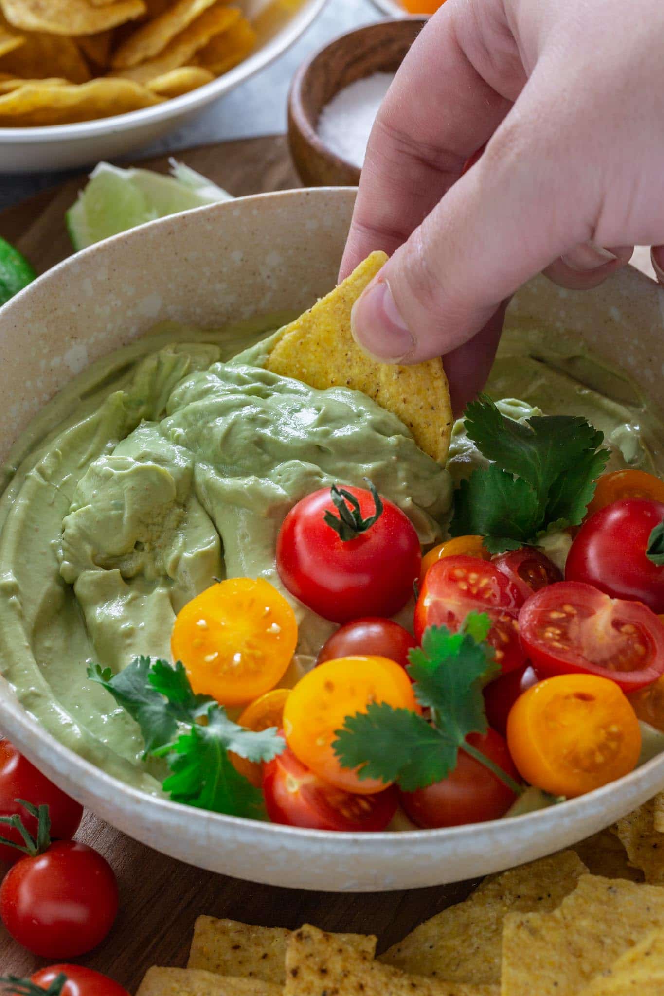 A tortilla scooping whipped avocado dip.