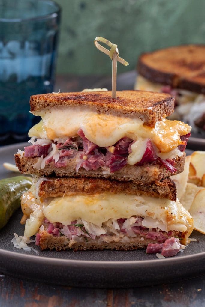 Two Reuben sandwiches stacked.