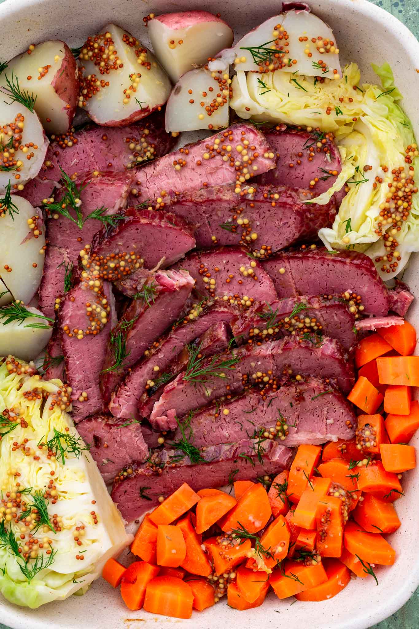 Sliced corned beef with cabbage, carrots and potatoes.