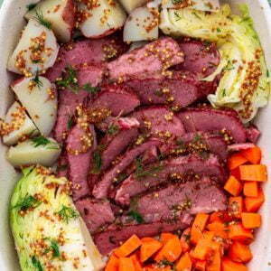 Sliced corned beef with cabbage, carrots and potatoes.