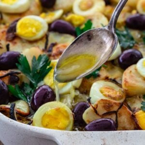 Pouring olive oil over bacalhau.