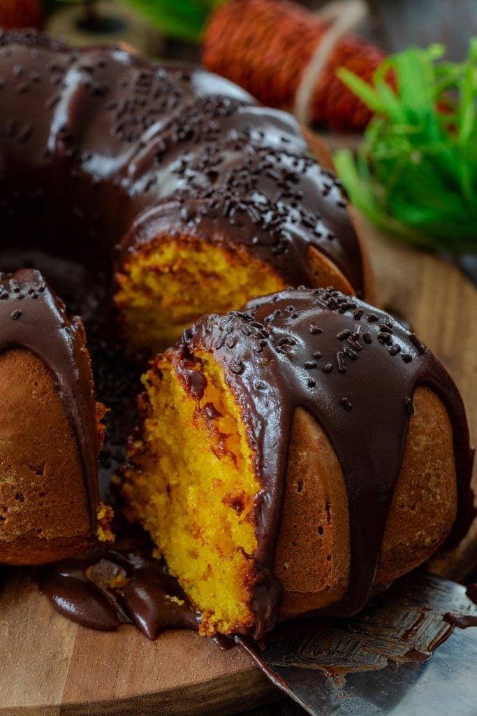 A slice of carrot cake covered with chocolate.