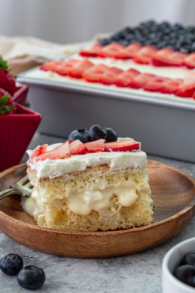 A slice of flag cake topped with berries.