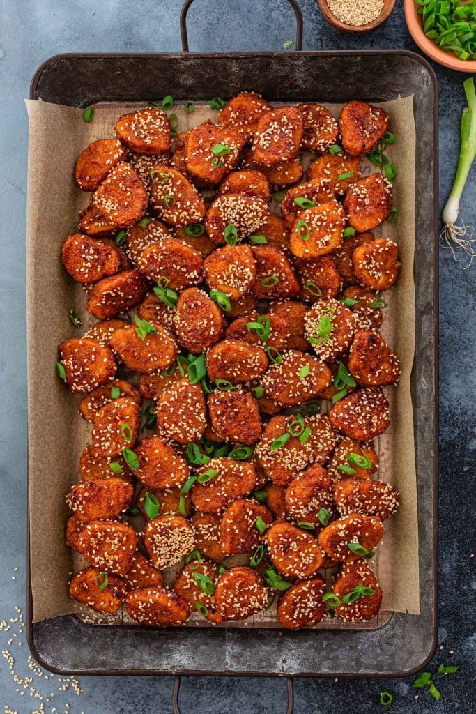 Glazed chicken nuggets topped with scallions and sesame seeds