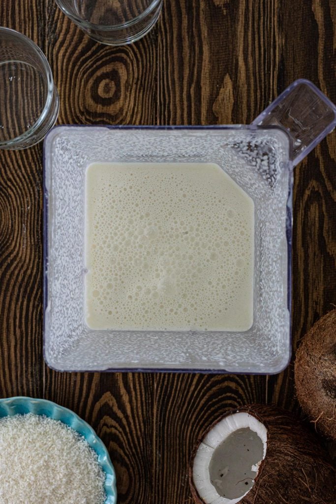 A blender jar filled with coconut cocktail.