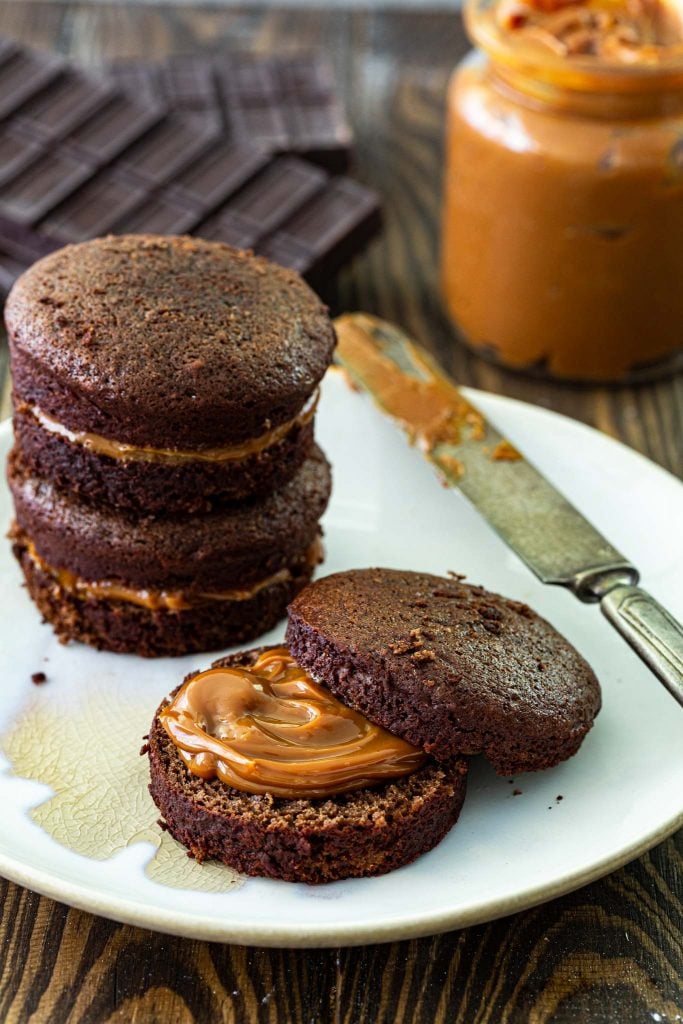 Spreading dulce de leche on the honey cakes.