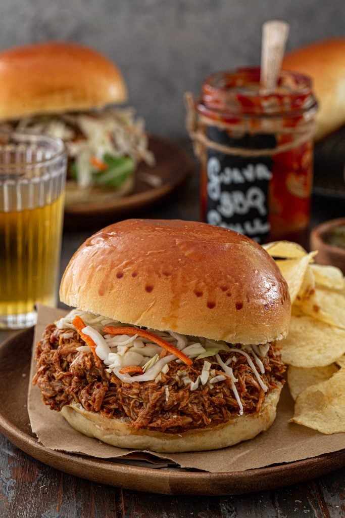 A sandwich made with Guava BBQ Pulled Chicken and cole slaw.