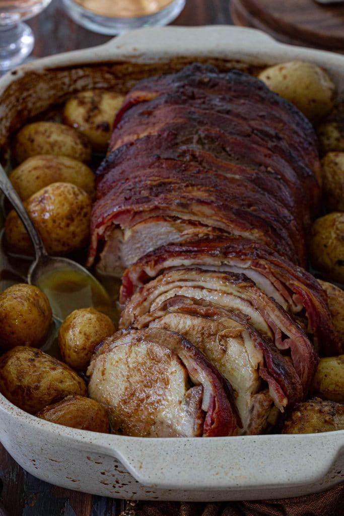 A succulent molasses-mustard glazed pork loin roast with potatoes.