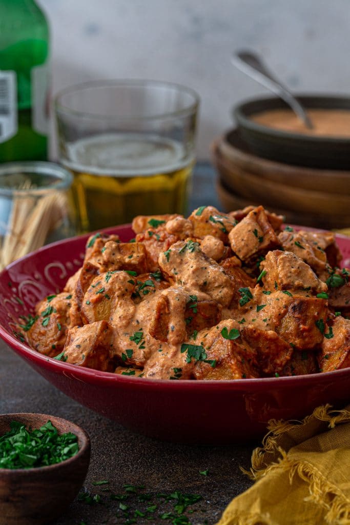 A bowl of patatas bravas smothered with Bravas Sauce.