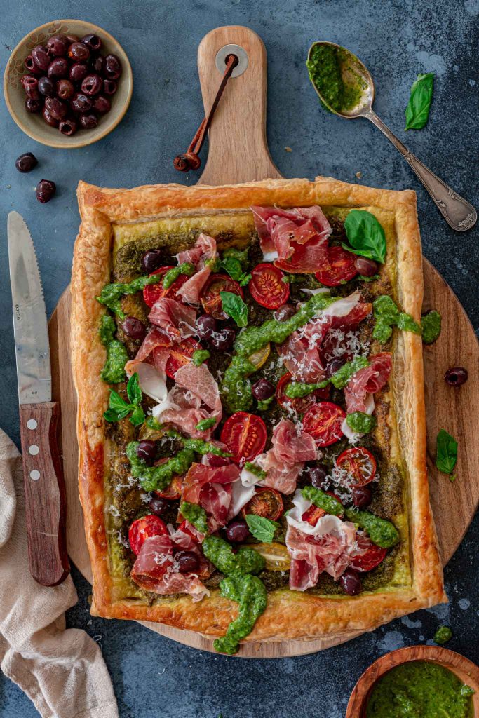 Prosciutto puff pastry tart made with pesto.