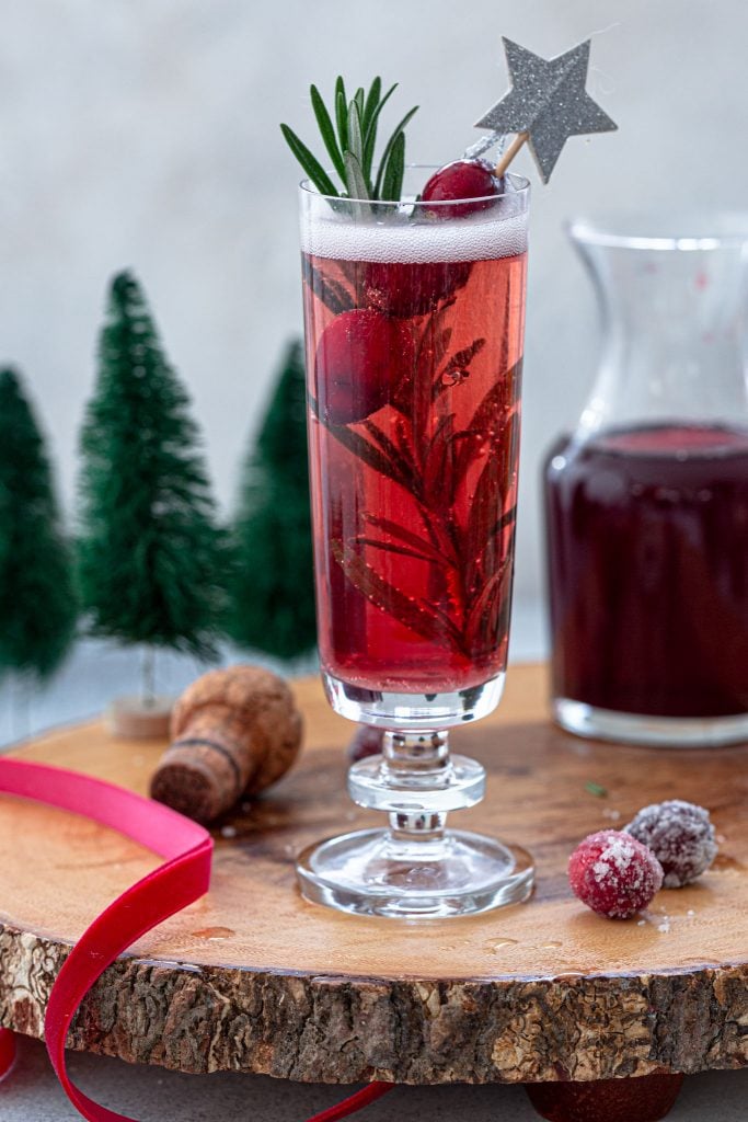 Christmas mimosa made with cranberry juice and rosemary.