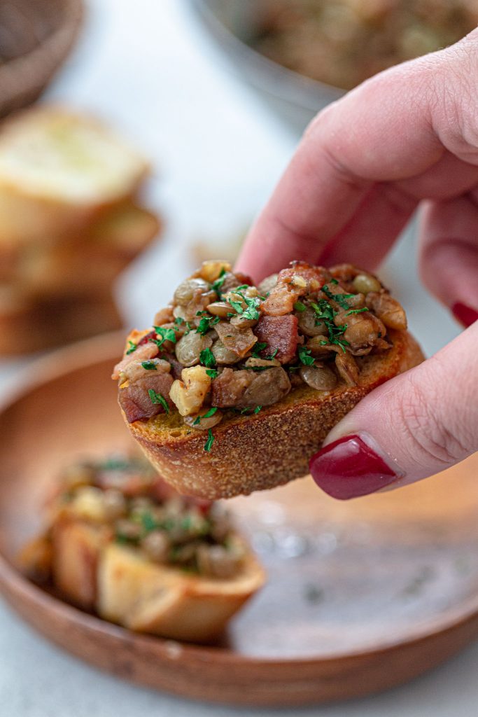 Warm lentil salad served with crostini, as an appetizer.