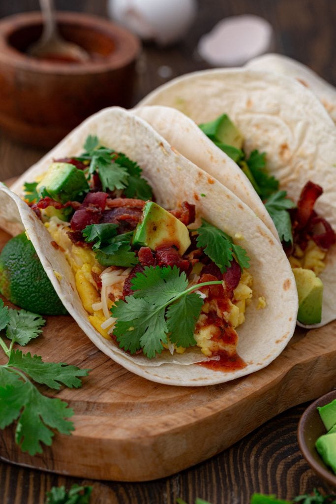 Low Carb Breakfast Tacos topped with avocados, salsa, cheese and cilantro.