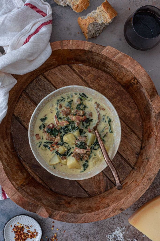 A bowl of Zuppa Toscana made with cream, bacon, sausage, potatoes and kale.