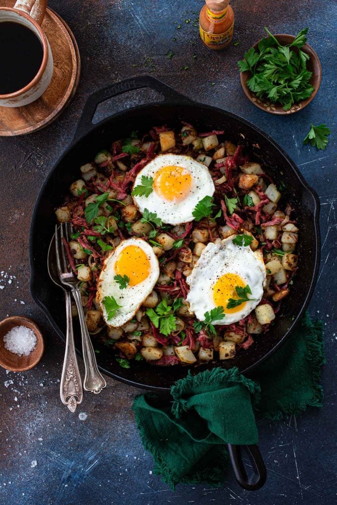 An overhead shot of corned beef hash with eggs.