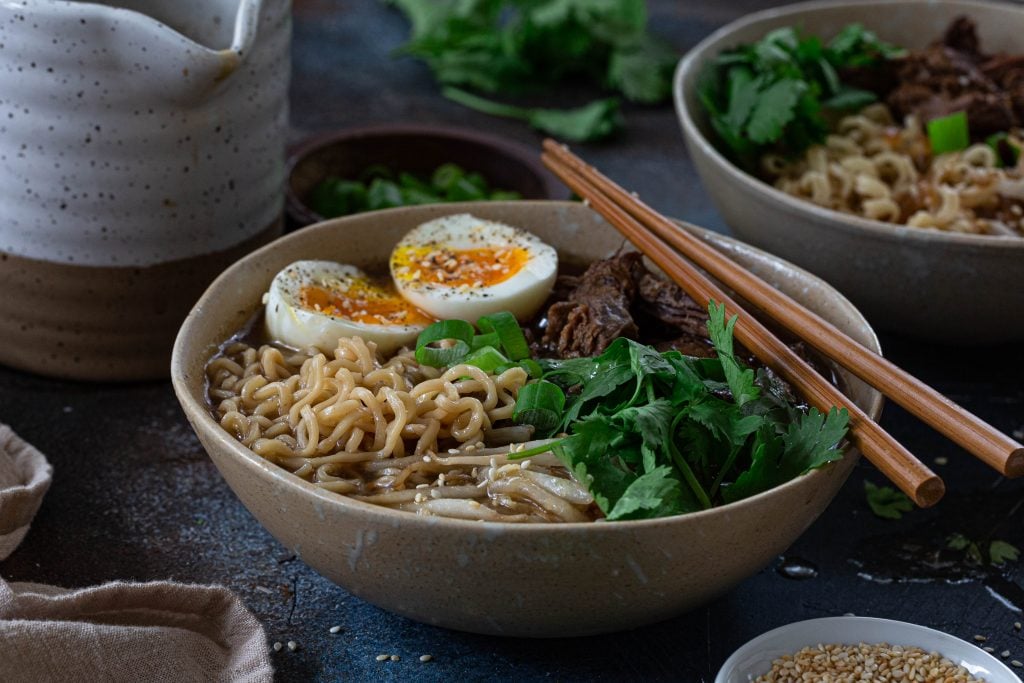 A bowl of ramen noodles with beef.