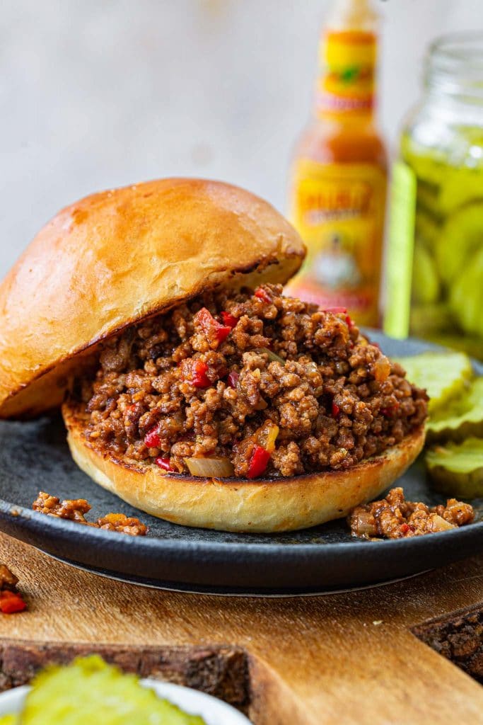 A homemade Sloppy Joe sandwich with the top bun on the side.