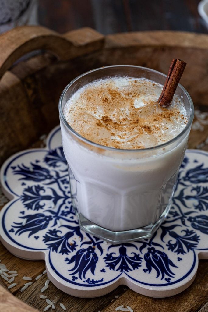 A glass of Mexican horchata garnished with cinnamon.