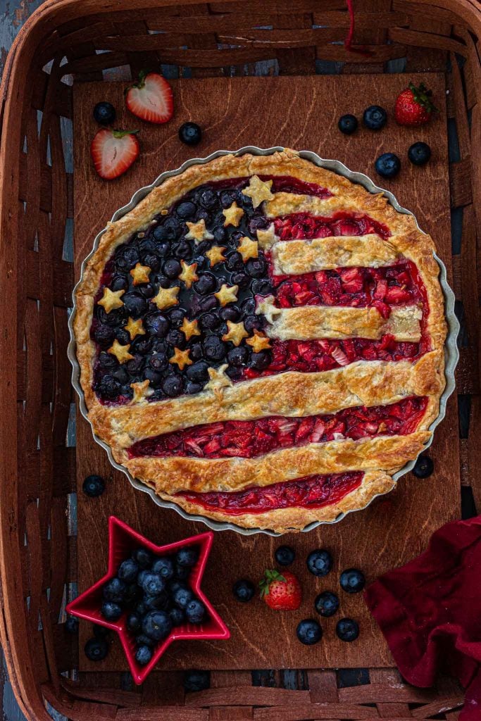 An overhead shot of an American flag  berry pie inside a basket.