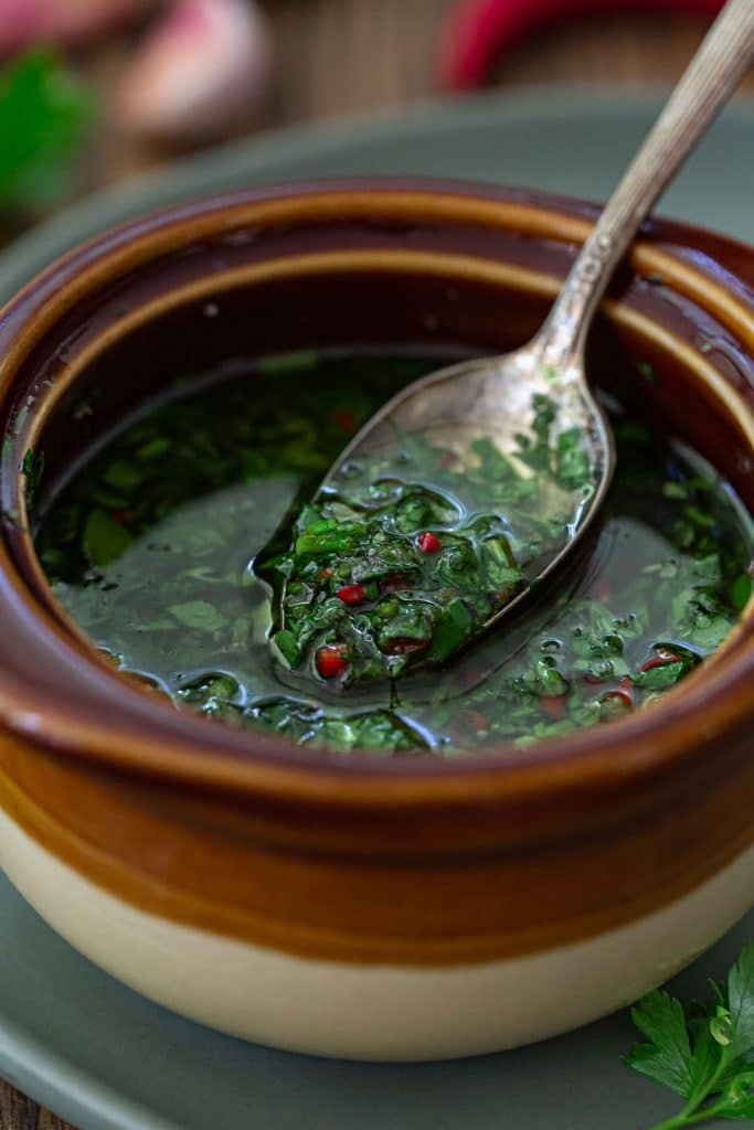 A closeup of a spoonful of Argentinian chimichurri sauce.