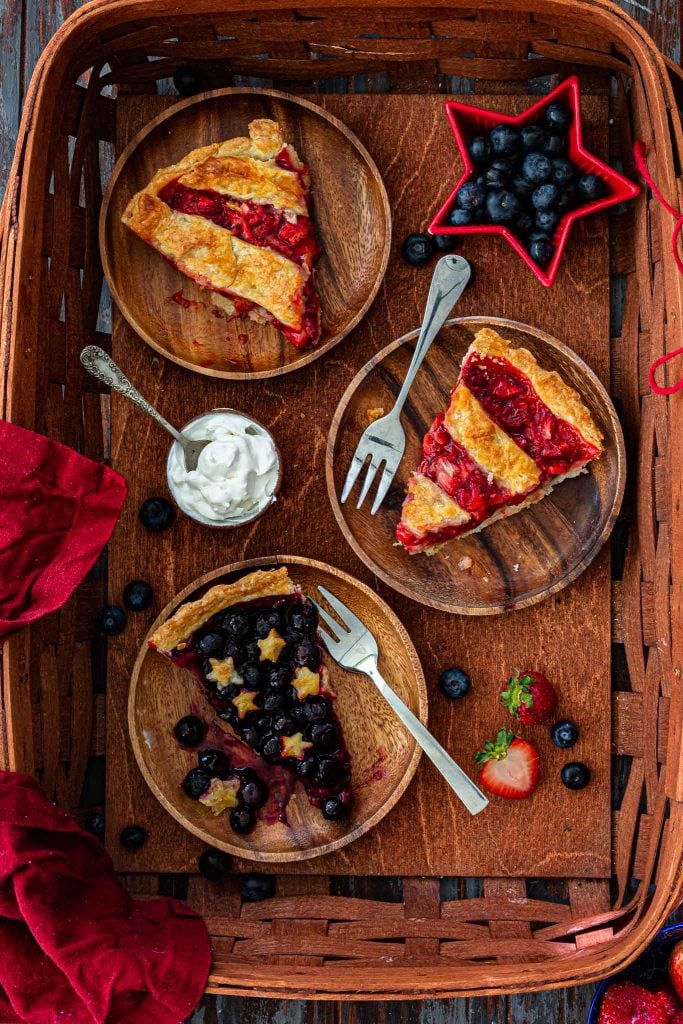 Three berry pie slices in a basket.