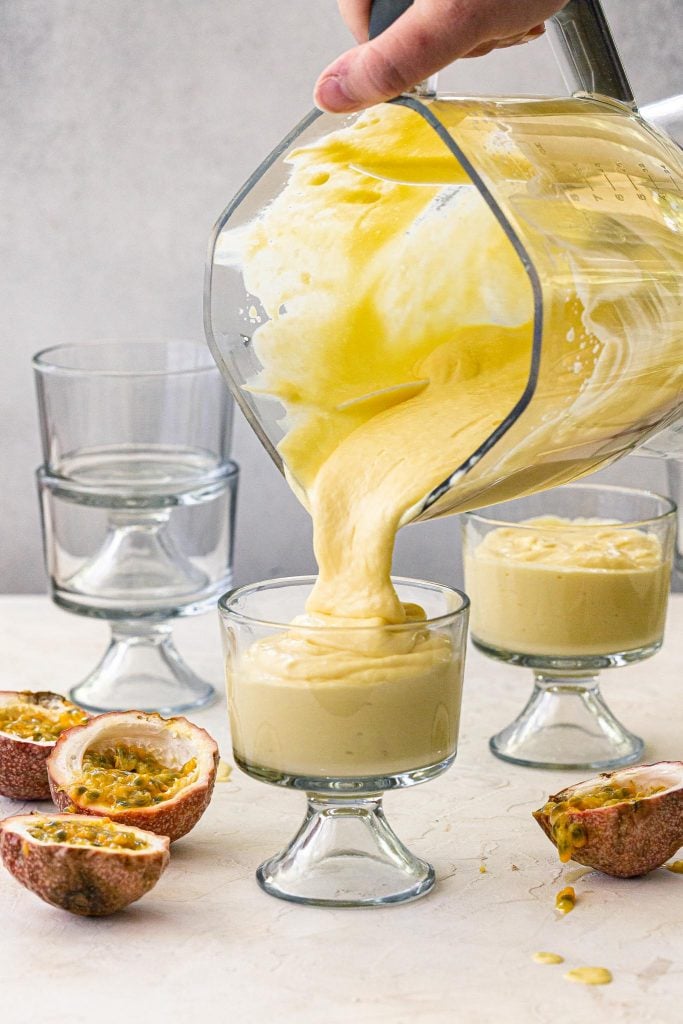 Pouring passion fruit mousse in individual glasses.