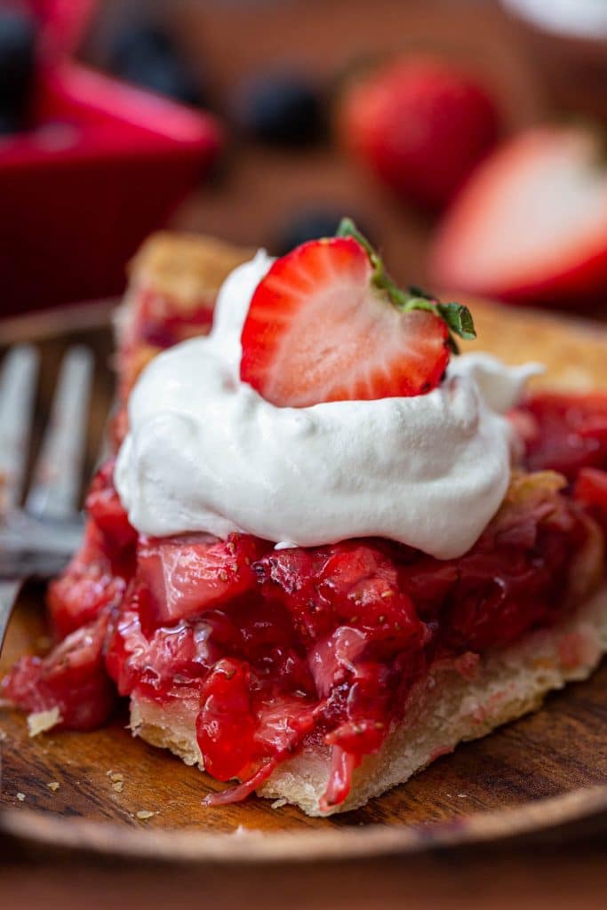 Strawberry pie topped with whipped cream.