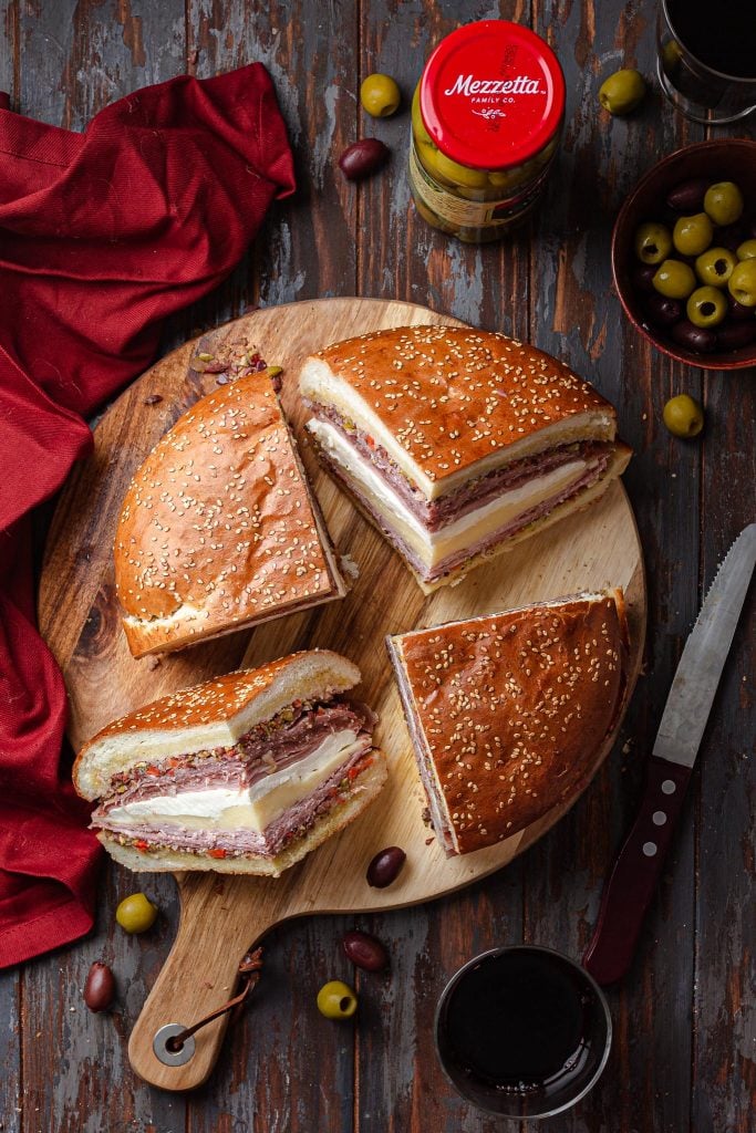 An overhead view of a Muffuletta sandwich, cut into 4 wedges.