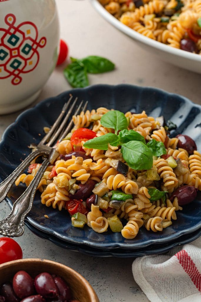 A plate of Mediterranean pasta, garnished with basil.