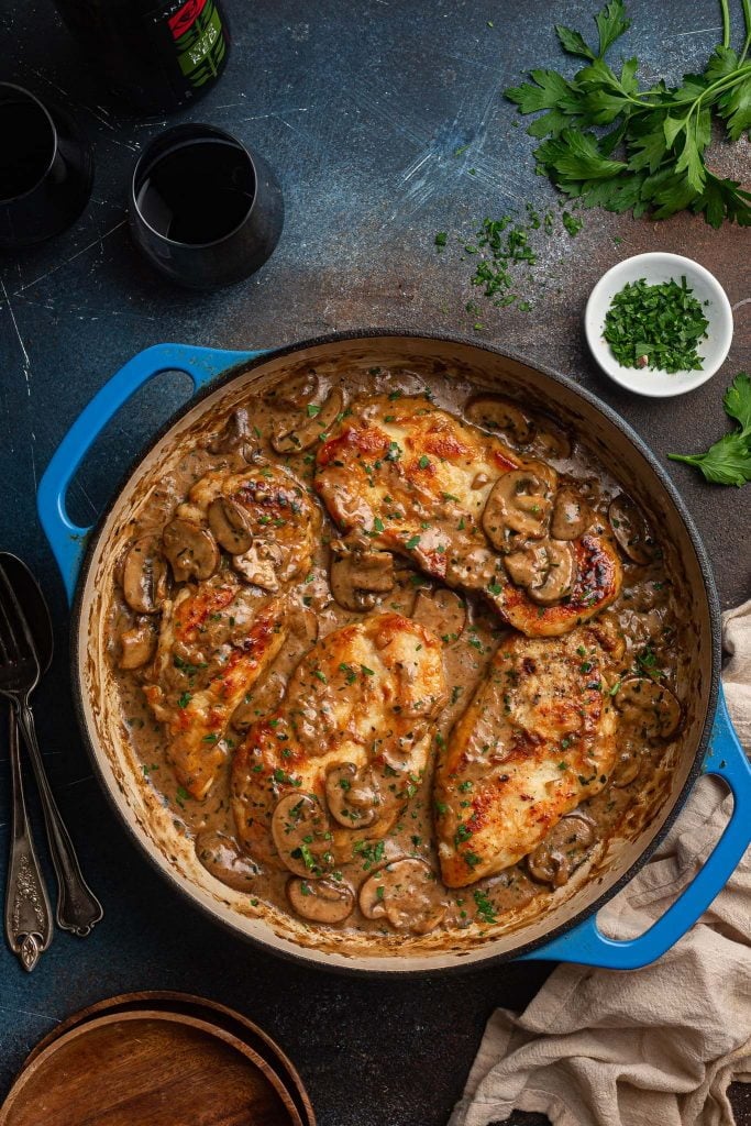 An overhead shot of a braiser dish with chicken marsala.