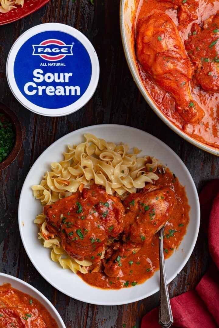 An overhead photo of a bowl of Chicken Paprikash with egg noodles.