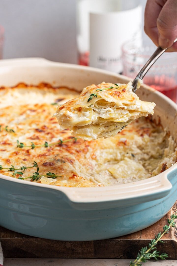 Potatoes Dauphinoise being scooped out of the gratin dish.